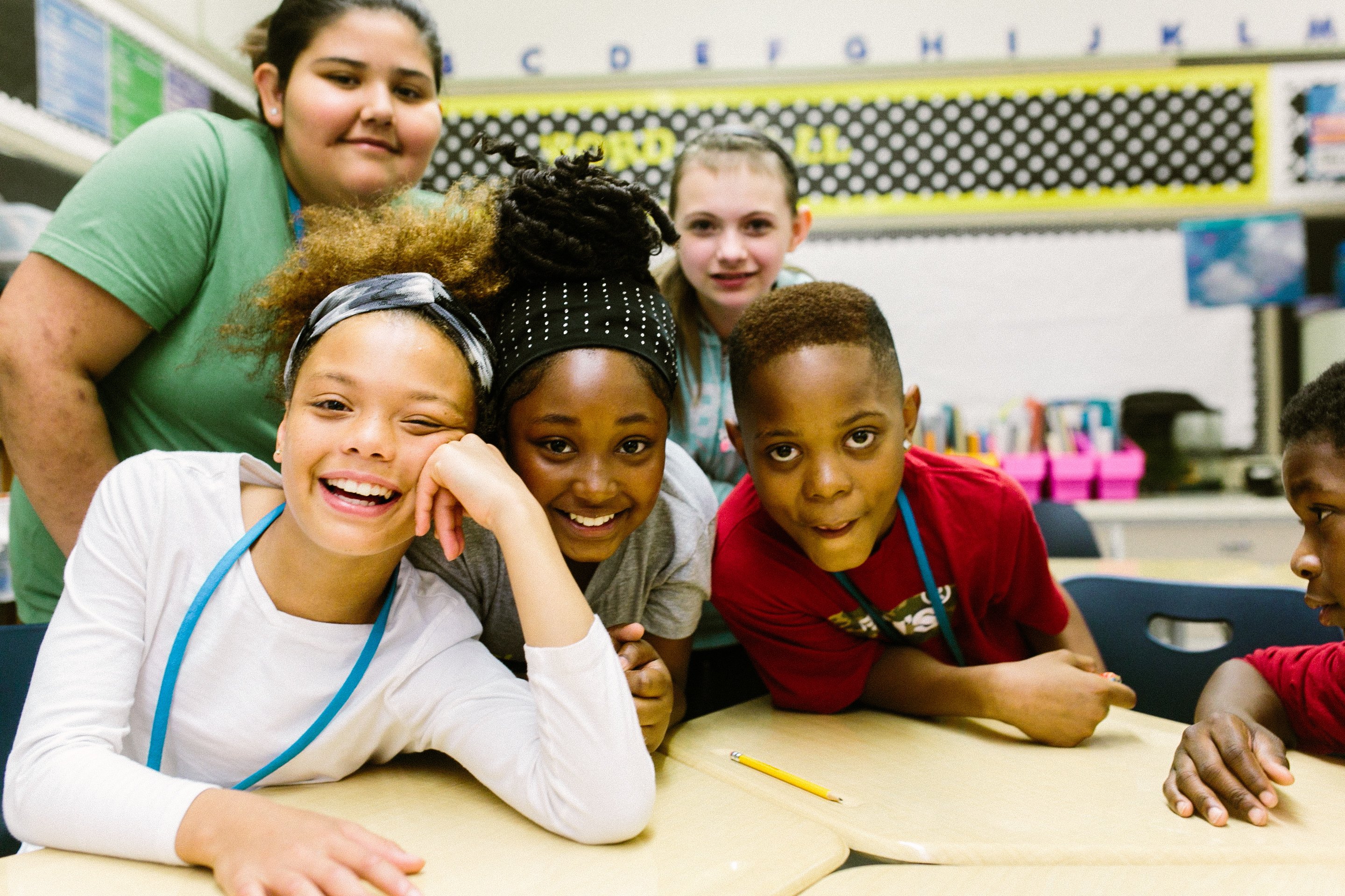 Kids smiling at classroom table